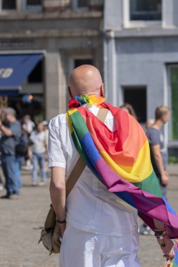 Amsterdam 'daki Gurur Yürüyüşü Gösterisinde Gökkuşağı Bayrağıyla çevrili Adam 20-7-2024