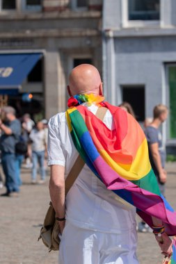 Amsterdam 'daki Gurur Yürüyüşü Gösterisinde Gökkuşağı Bayrağıyla çevrili Adam 20-7-2024