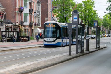 Amsterdam 'daki tramvay durağından 19 numaralı tramvay giriyor. Hollanda 27-5-2023.