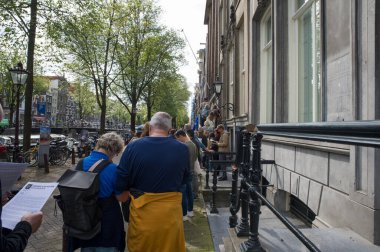 Hollanda, Amsterdam 'daki Huis Van Brienen' deki açık anıtın önünde dikiliyor. 14-9-2024