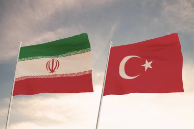 İRAN ve TURKEY 'nin bayrakları bulutlu mavi gökyüzü arkaplanıyla dalgalanıyor, ülkeler arasındaki ilişkiler..