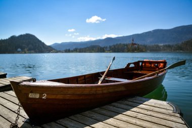 Bled, Slovenya - 10 Nisan 2023: Slovenya 'nın güneşli bahar gününde Slovenya' da göl kenarında küçük bir tekne kanadı