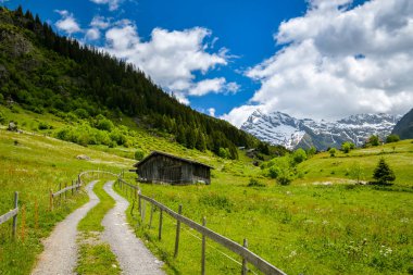 Bristen, İsviçre - 13 Haziran 2020: Güneşli bir günde İsviçre 'nin Bristen kentinde Golzernsee Gölü yakınlarında küçük ahşap bir ev