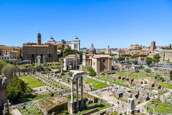 Rome, Italy - April 18, 2022: Crowds of tourists visiting Roman Forum in Rome, Italy during sunny day in April 2022