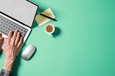 Dizüstü bilgisayarın üzerinde boş ekranlı bir adamın elleri. Boş kopyalama alanı olan üst görünüm.