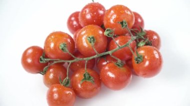 Beyaz arka planda dönen küçük kırmızı kiraz domateslerinin üst görünümü