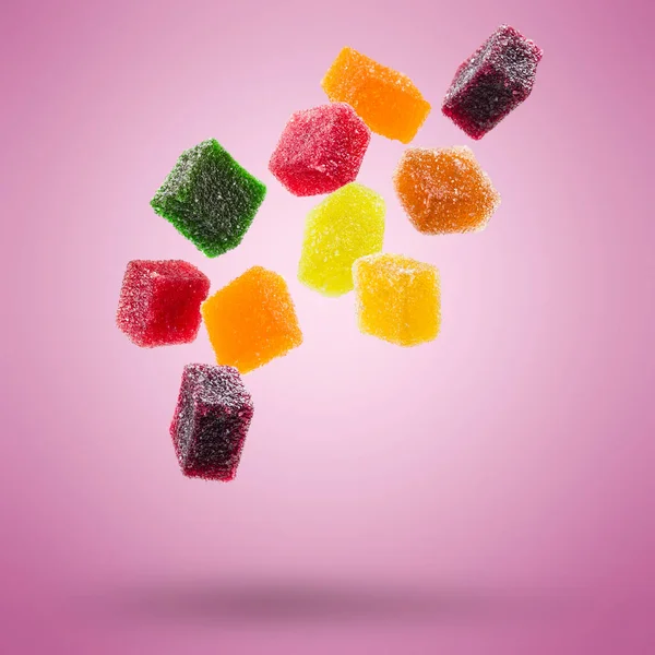 在彩色背景上漂浮的各种果冻糖果 — 图库照片