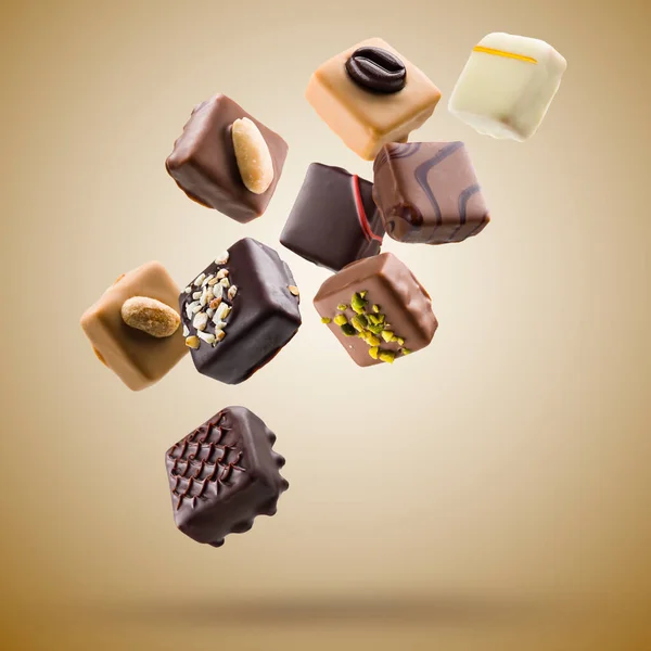 Pralinas Chocolate Sortidas Flutuando Fundo Marrom — Fotografia de Stock