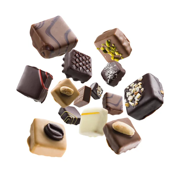 Různé Čokoládové Pralinky Padající Bílém Pozadí — Stock fotografie
