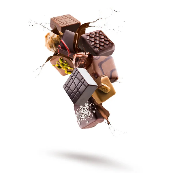 Diverse Chocolade Pralines Drijvend Met Gesmolten Chocolade Splash Witte Achtergrond Rechtenvrije Stockafbeeldingen