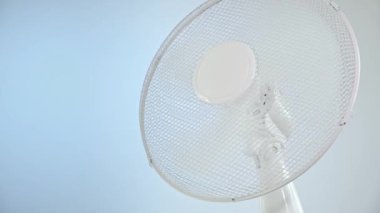 Mavi arkaplandaki taşınabilir elektrikli vantilatörü aç.