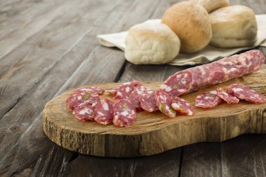 Kesme tahtasında dilimlenmiş İtalyan salamı..