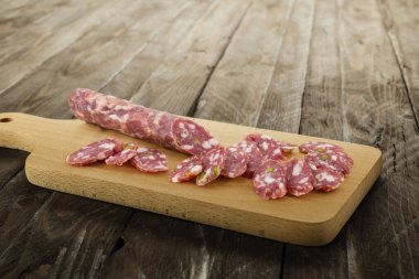 Kesme tahtasında dilimlenmiş İtalyan salamı..