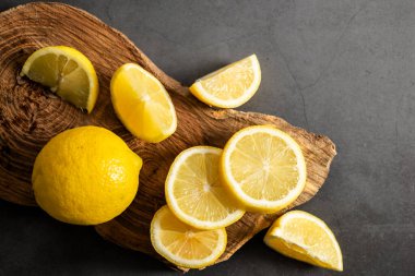 Dilimlenmiş limon koyu arkaplanda üst görünüm.