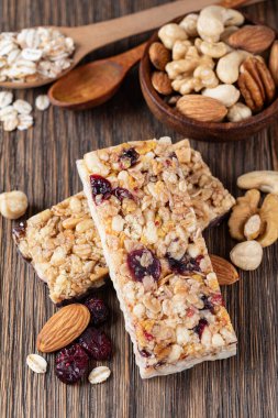 Tahta arka planda fındıklı ve kurutulmuş meyveli granola barları