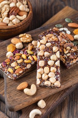Tahta arka planda fındıklı ve kurutulmuş meyveli granola barları