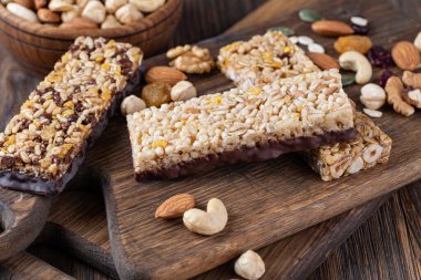 Tahta arka planda fındıklı ve kurutulmuş meyveli granola barları