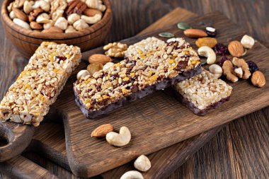 Tahta arka planda fındıklı ve kurutulmuş meyveli granola barları