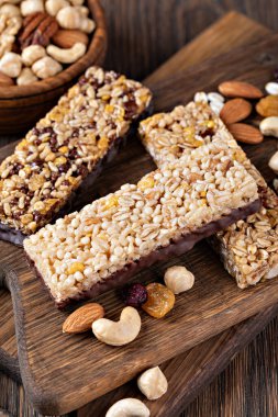 Tahta arka planda fındıklı ve kurutulmuş meyveli granola barları