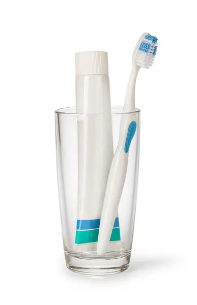白い背景にガラスで歯ブラシと歯磨き粉 ストック写真