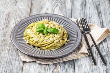 Pesto soslu makarna ve taze fesleğen yaprağı. Beyaz arkaplanda izole.