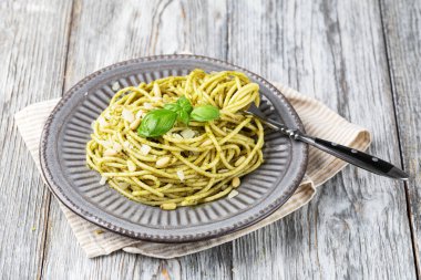 Pesto soslu makarna ve taze fesleğen yaprağı. Beyaz arkaplanda izole.