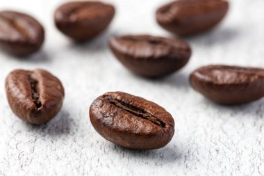 Ahşap arka planda kavrulmuş kahve çekirdekleri..