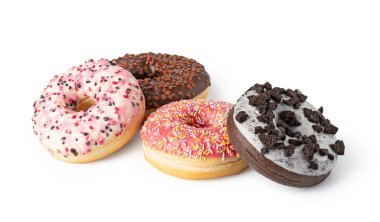 Beyaz arka planda izole edilmiş renkli şeker parçacıkları ve kurabiye kırıntıları ile nefis buzlu donutlar, cezbedici bir tatlı gösterisi yaratıyor.