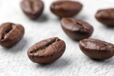 Ahşap arka planda kavrulmuş kahve çekirdekleri..