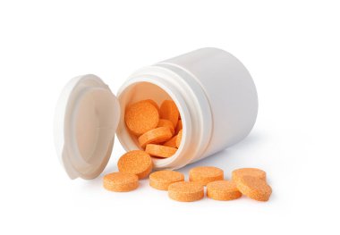 Turuncu C vitamini tableti beyaz bir zemin üzerinde beyaz bir plastik hap şişesinden dökülüyor, bu ilaç, sağlık ve sağlığı temsil ediyor.