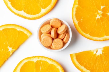 Turuncu renkli haplar beyaz arka planda izole edilmiş C vitaminleri.