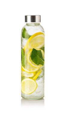 Dilimlenmiş limonlar, nane yaprakları ve buz küpleriyle dolu şişenin içinde sağlıklı bir yaşam tarzı var.