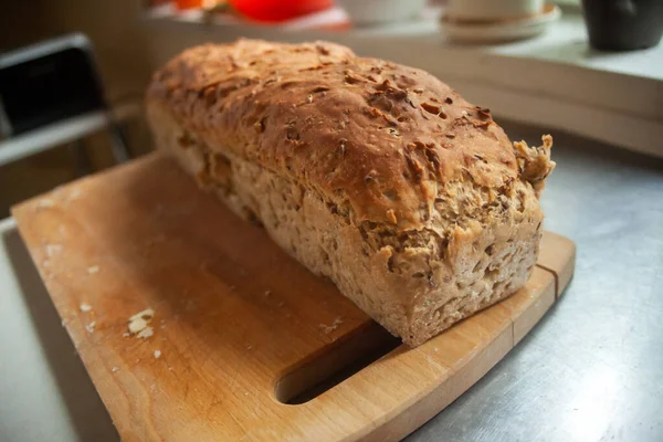 Home-baked loaf of bread on a wooden board in kitchen