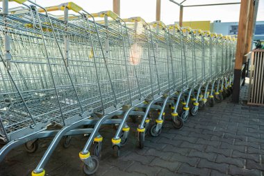 A row of large shopping carts on wheels, view in sunny day