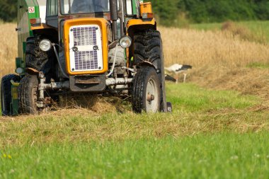 Yaz günü saman toplamak için Polonyalı eski traktör ve balya makinesi.