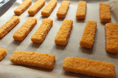 Kağıda konmuş altın ekmek kırıntıları ve bir yemek tepsisi.