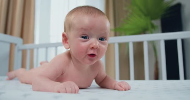 Roztomilý Šťastný Novorozenec Leží Bílé Postýlce Břiše Radostně Dívá Kamery — Stock video