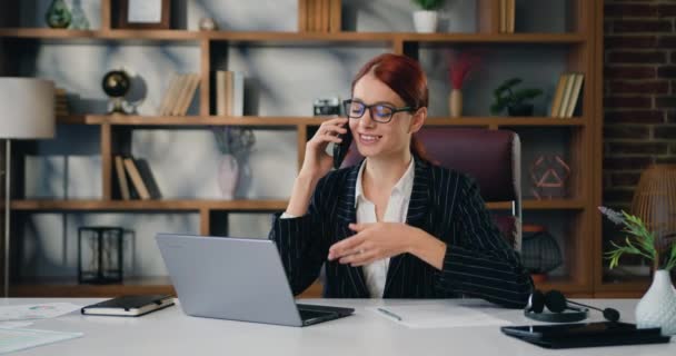 Bilgisayarda Çalışan Genç Meşgul Bir Kadını Modern Ofiste Telefonla Konuşuyor — Stok video