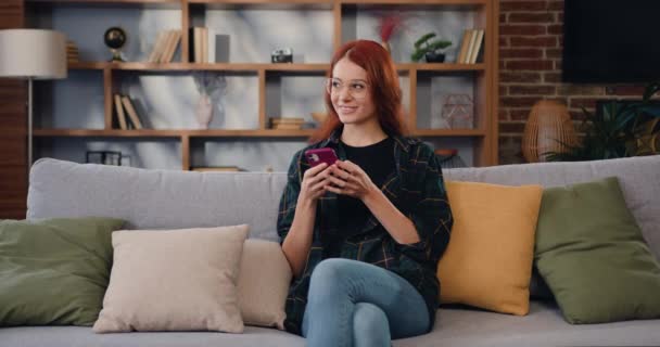 Улыбающаяся Рыжеволосая Женщина Очках Проверяющая Соцсети Играющая Игры Делающая Покупки — стоковое видео