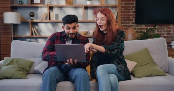 Casal Jovem Multiétnico Amor Sentar Sofá Lendo Ótimas Notícias Laptop — Vídeo de Stock