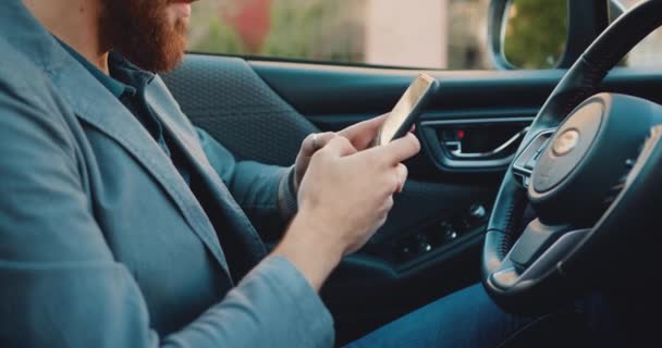 車のハンドヘルドショットで 使用して スマートフォンを入力し 事業者を閉じます テクノロジーの概念 不明な男性のプロの車で電話を使用してチャット スローモーション — ストック動画