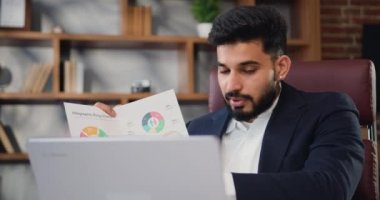 Bin yıllık yakışıklı Arap iş adamı koçunun portresi dizüstü bilgisayarla konuşuyor sanal görüşme yapıyor, profesyonel eğitim pazarlığı yapıyor.