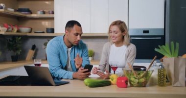 Çift evdeki cep telefonundan alışveriş yapmayı seviyor. Afrika kökenli Amerikalı erkek ve kadın mobil uygulama kullanıyor, havalı filtrelerin tadını çıkarıyor akıllı telefonları kullanarak birlikte vakit geçiriyorlar. Yavaş çekim.