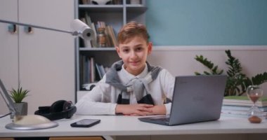 Kameraya bakıp gülümseyen ve komik suratlar yapan sevimli çocuk portresi, mutlu çocuk. Kameraya bakıyor ve büyüleyici bir şekilde gülümsüyor. Yavaş çekim.