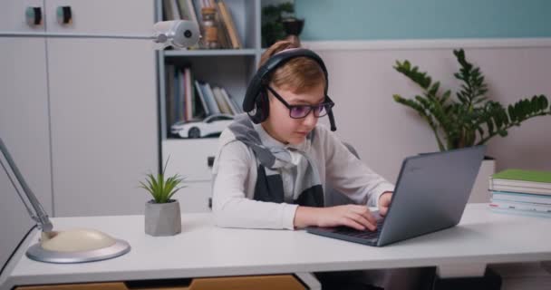 Joyful Little Boy Eyeglasses Headphones Playing Video Game Using Laptop — Stock Video