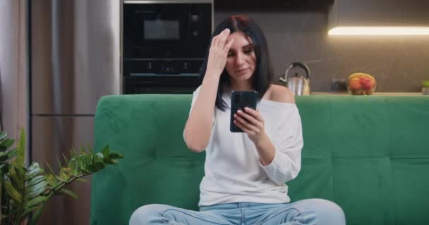 Happy Young Woman Sitting Green Sofa Using Smartphone Smiling Modern — Vídeo de Stock