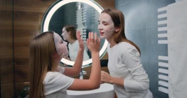 Girl and her sister beauty product for skincare while in modern bathroom with family facial mask and dermatology. Woman and child together for health, cosmetics and wellness of skin Home spa concept