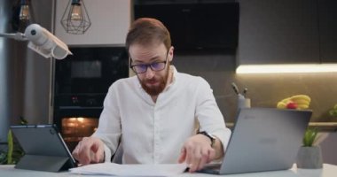 Bilgisayarla konuşan yakışıklı iş adamının portresi video konferans görüşmesi yapıyor. Evindeki bir kanepeden iş yerinden bir erkekle video görüşmesi ve belgeler. Yavaş çekim.