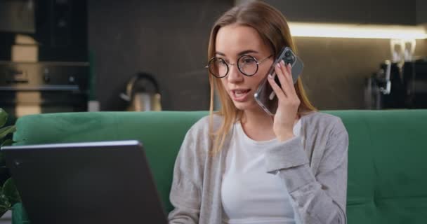 Gülümseyen Genç Kadını Telefonda Dizüstü Bilgisayarla Konuşuyor Evde Oturuyor Müşteriyle — Stok video