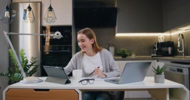 Genç bayan girişimci modern ofis masasında dizüstü bilgisayar kullanarak notlar alıyor. Evde internet üzerinden web dersi izliyor ya da özel ders dinliyor. Uzaktan eğitim kavramı. Yavaş çekim.